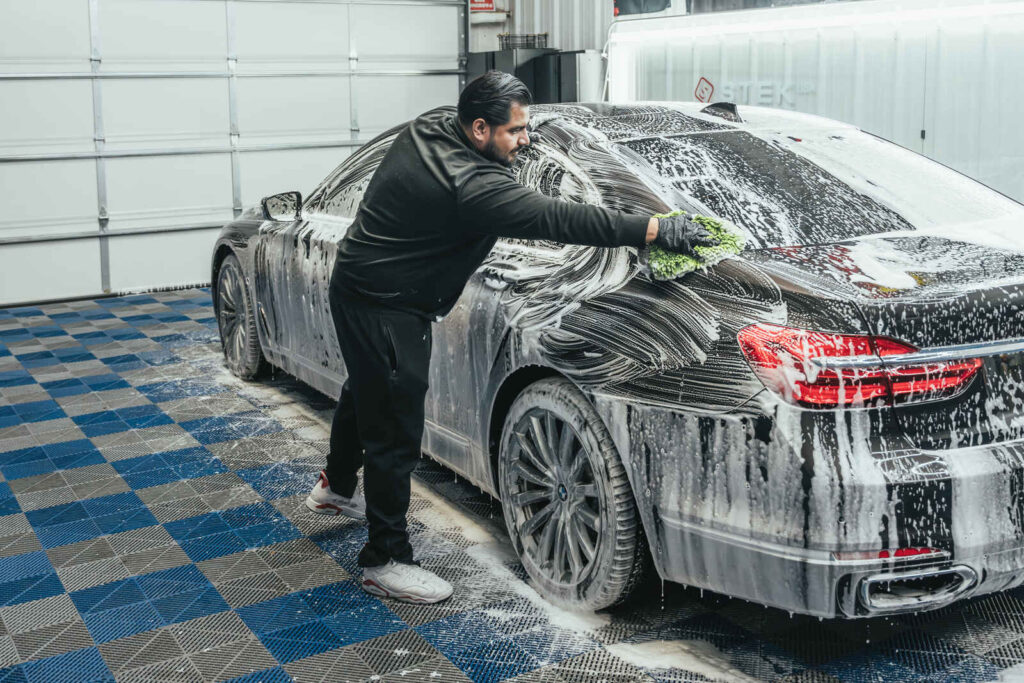 AutoPro DFW technician performing detailed auto cleaning on a car interior and exterior.